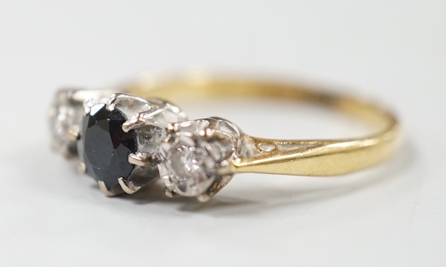 A modern 18ct gold, single stone sapphire and two stone illusion set diamond ring, size N, gross weight 3.4 grams.